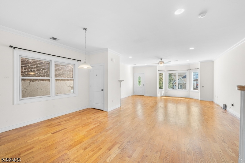233 5th Street, Unit B Fairview, NJ 07022 - Photo 12 of 31 a view of an empty room with a window and wooden floor