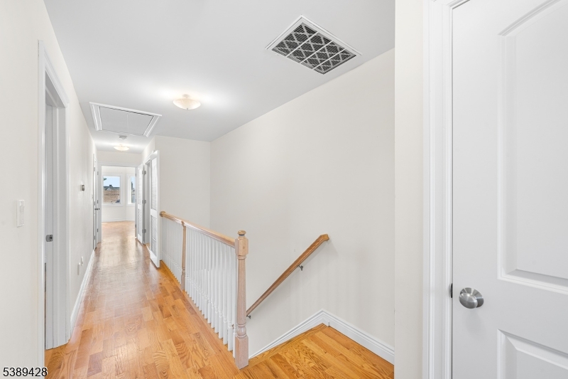 233 5th Street, Unit B Fairview, NJ 07022 - Photo 16 of 31 a view of a hallway with wooden floor and staircase