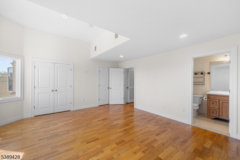 233 5th Street, Unit B Fairview, NJ 07022 - Photo 21 of 31 a view of an empty room with wooden floor and a bathroom