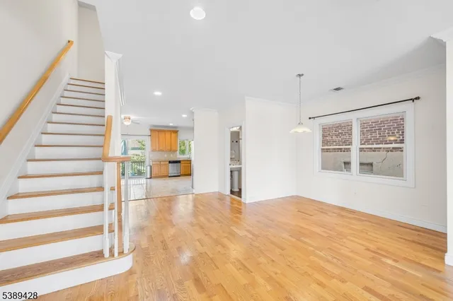 a view of an empty room with wooden floor and windows
