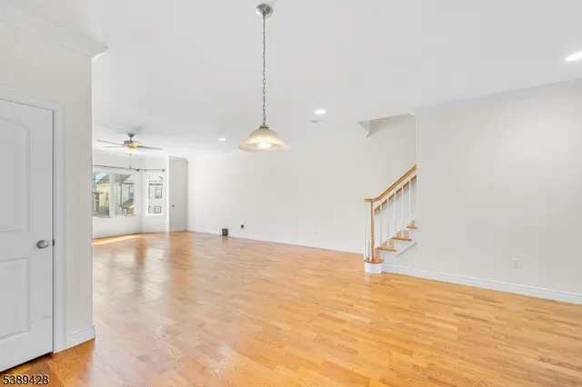 a view of an empty room with window and wooden floor