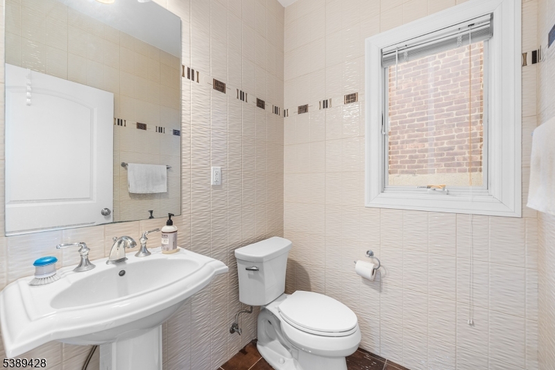 233 5th Street, Unit B Fairview, NJ 07022 - Photo 8 of 31 a bathroom with a sink a toilet and a mirror