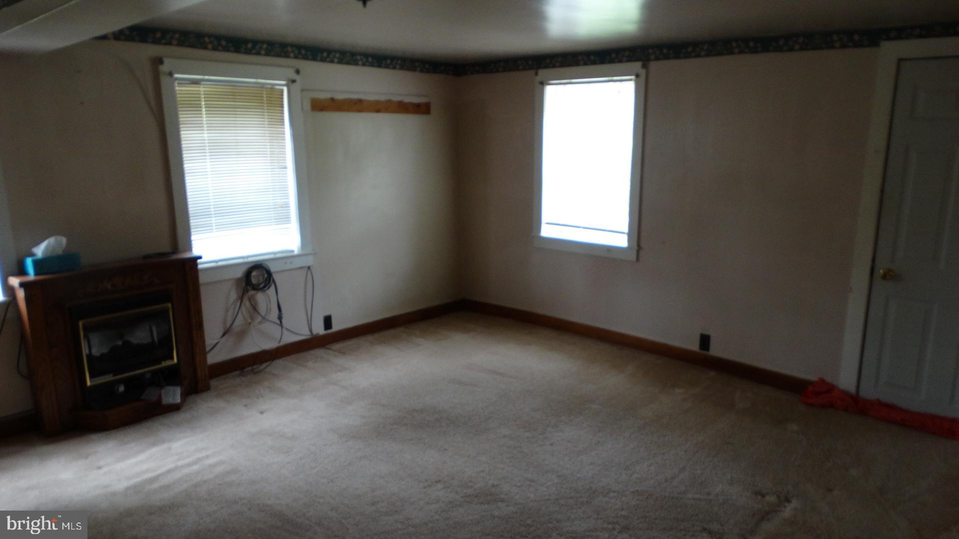 22209 Pondsville Road Smithsburg, MD 21783 - Photo 53 of 55 a view of an empty room with a fireplace and a window