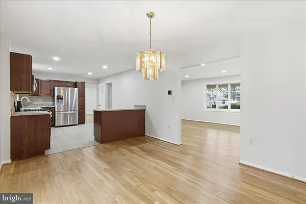a large kitchen with granite countertop a sink a stove top oven and wooden cabinets