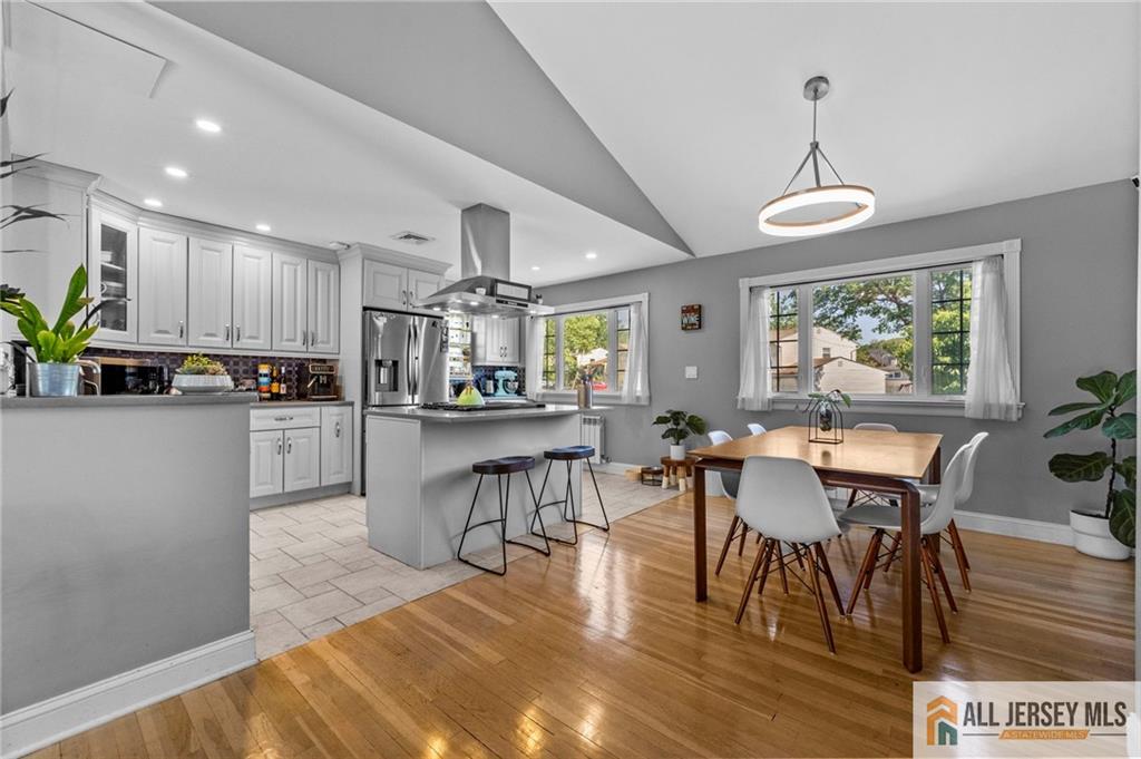 21 Starlight Drive Colonia, NJ 07067 - Photo 11 of 41 a kitchen with stainless steel appliances granite countertop a stove top oven a sink dishwasher a dining table and chairs with wooden floor