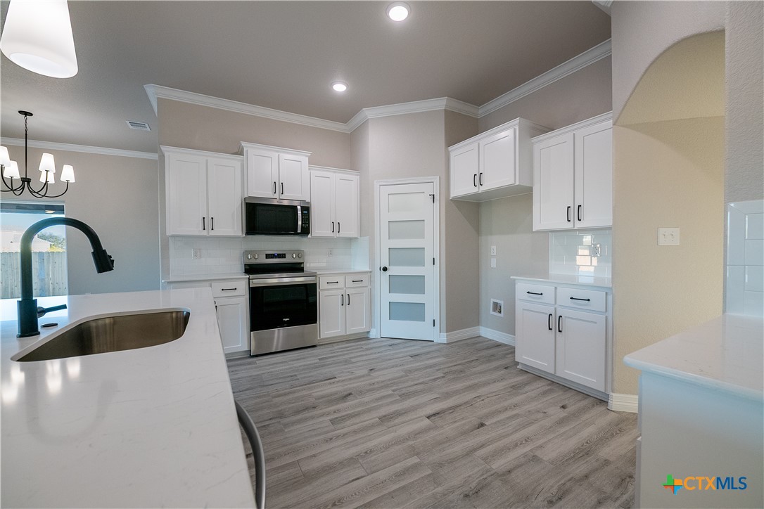 1404 Red Rock Road Hewitt, TX 76643 - Photo 11 of 30 a kitchen with granite countertop a refrigerator stove and sink