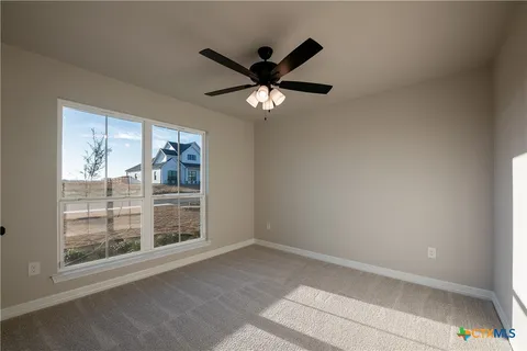 a view of a livingroom with a ceiling fan and window