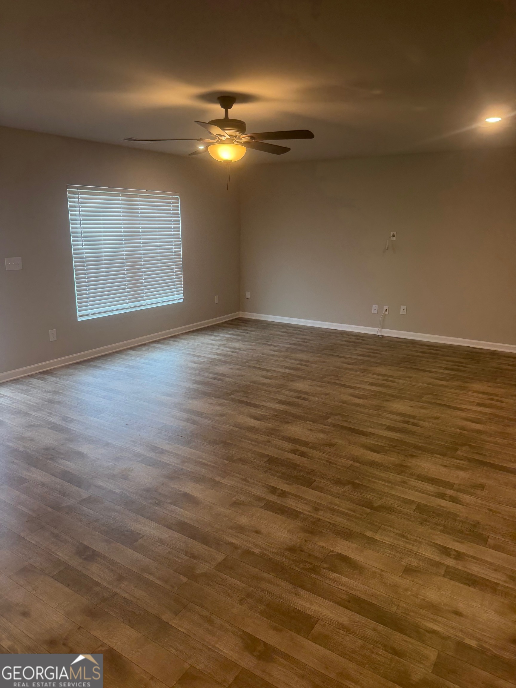399 Toronto Circle, Unit 281 Hampton, GA 30228 - Photo 6 of 18 a view of an empty room with window and wooden floor