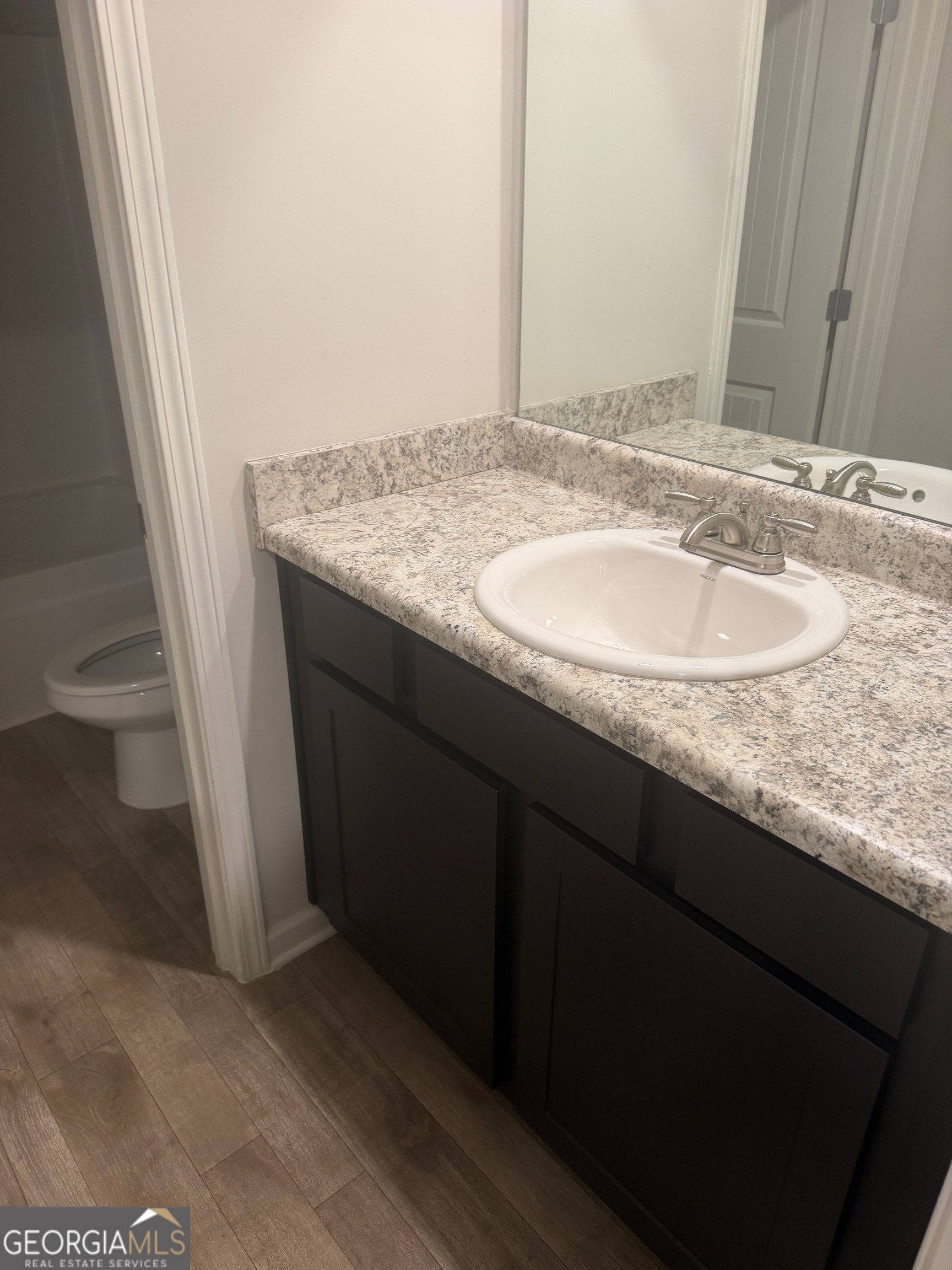 399 Toronto Circle, Unit 281 Hampton, GA 30228 - Photo 8 of 18 a bathroom with a granite countertop sink and a mirror