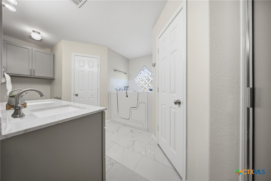 658 Devin Drive Temple, TX 76502 - Photo 17 of 30 a bathroom with a granite countertop sink and a mirror