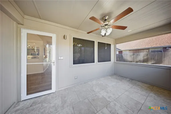 an empty room with fan and windows