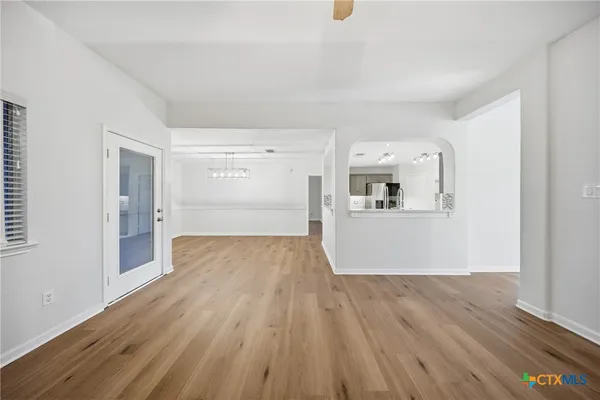 a view of a kitchen with wooden floor and a refrigerator