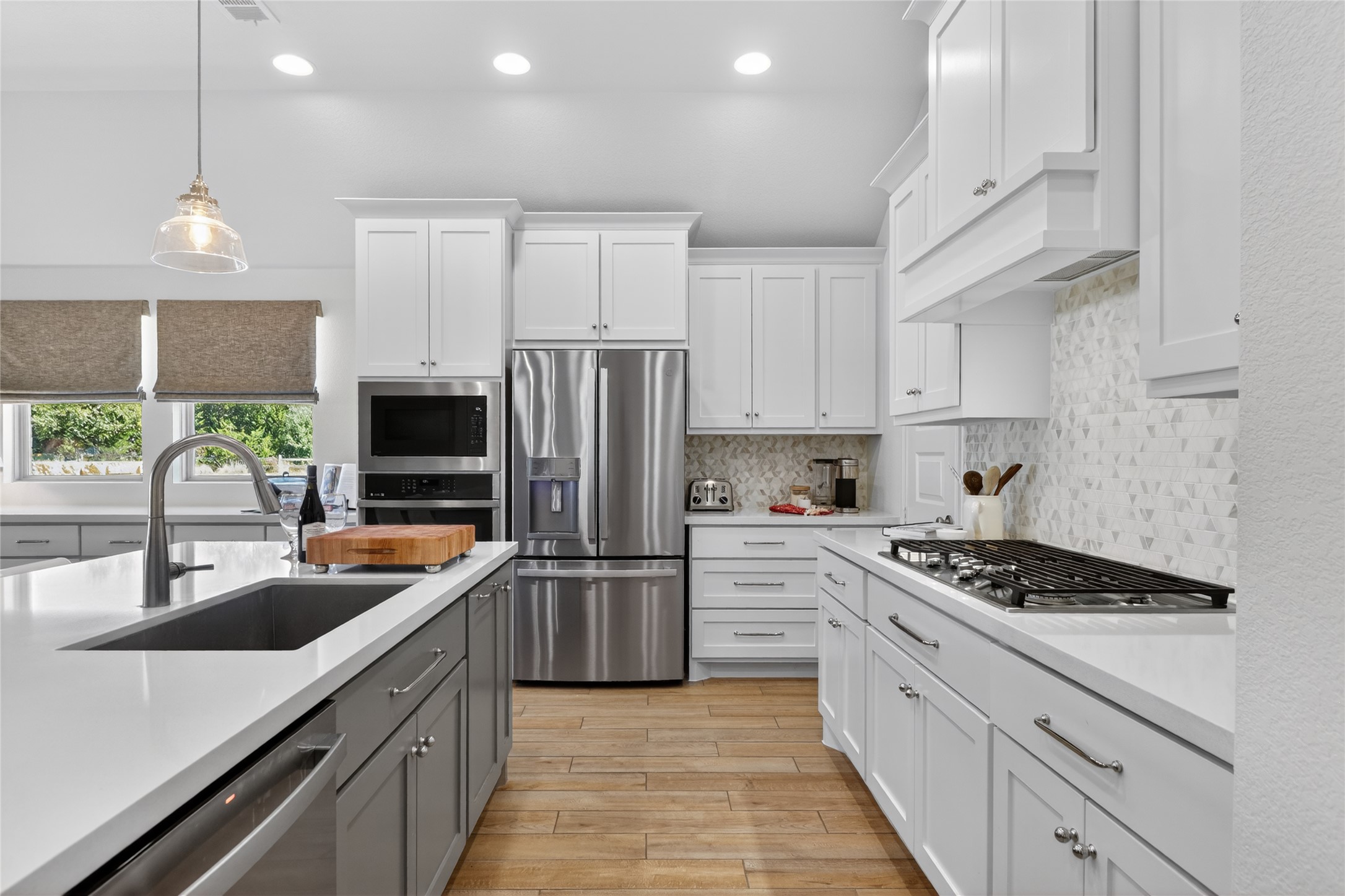 100 Peach Orch Lane Georgetown, TX 78628 - Photo 3 of 40 a kitchen with stainless steel appliances a sink dishwasher a refrigerator a stove and white cabinets with wooden floor