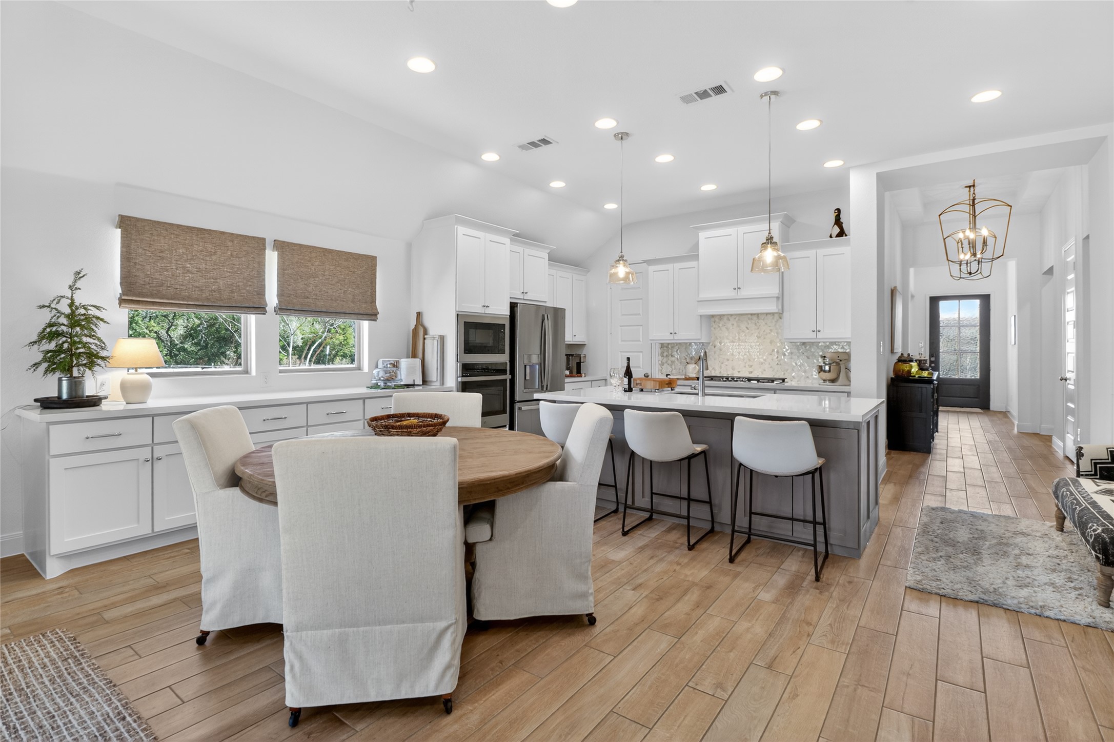 100 Peach Orch Lane Georgetown, TX 78628 - Photo 6 of 40 a living room with kitchen island furniture a wooden floor and a kitchen view