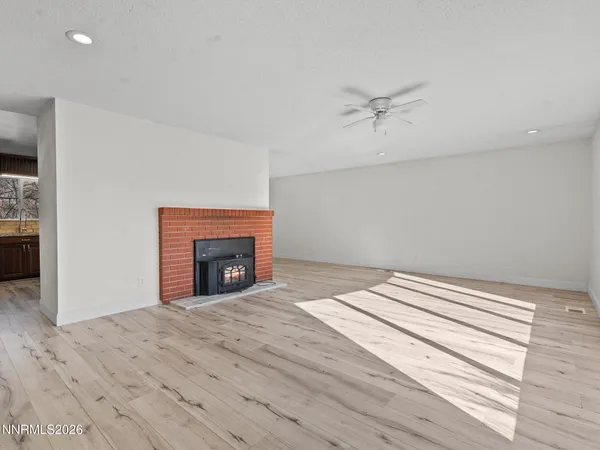 wooden floor fireplace and window in an empty room