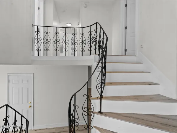 a view of staircase with wooden floor and white walls