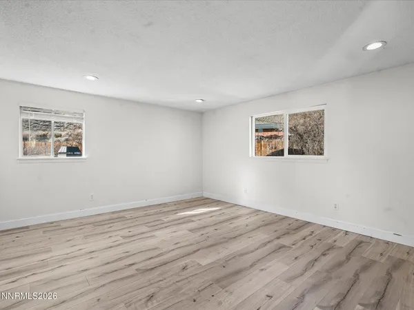 a view of empty room with wooden floor