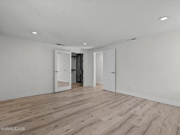 a view of an empty room with wooden floor