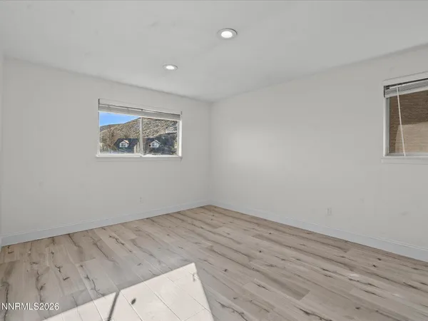 a view of empty room with wooden floor