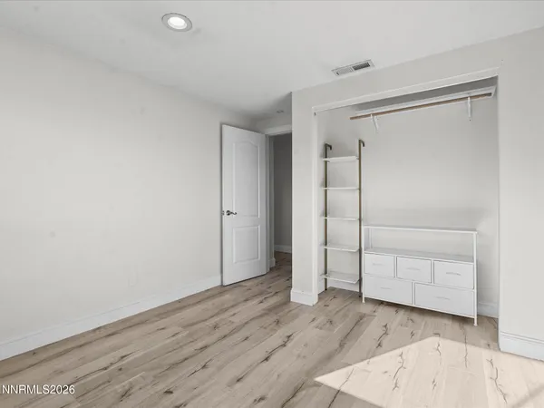 an empty room with wooden floor and closet