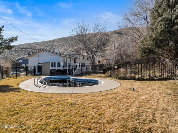 a front view of house with yard and trees in the background