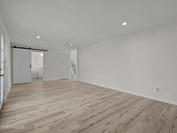 a view of empty room with wooden floor