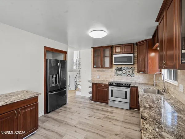 a kitchen with stainless steel appliances granite countertop a refrigerator stove and sink