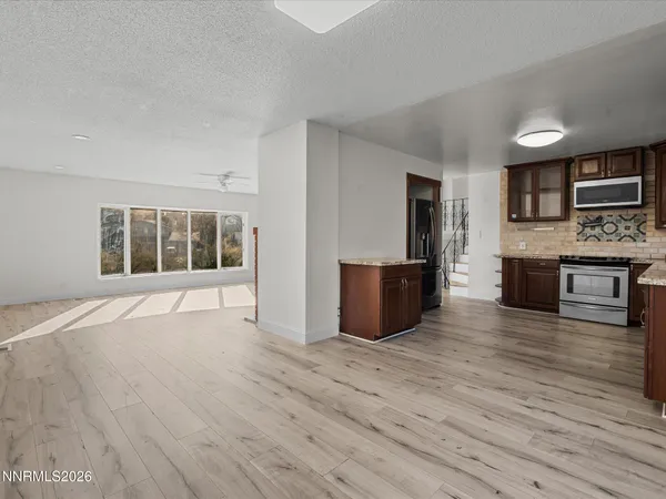 a big room with wooden floor and fireplace