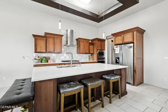 a living room with stainless steel appliances kitchen island granite countertop furniture and a refrigerator