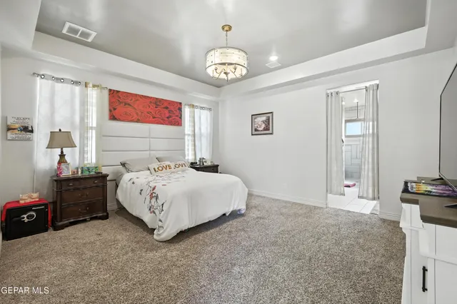 a bedroom with a bed and a chandelier