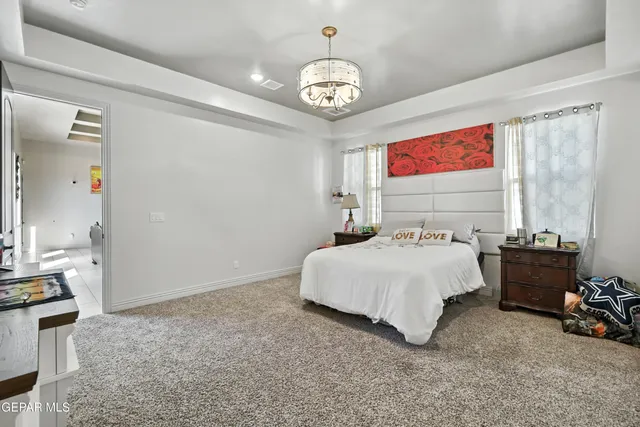 a bedroom with a bed and a chandelier