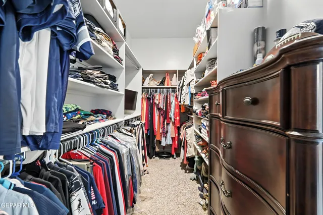 a view of walk in closet with clothes and shoes