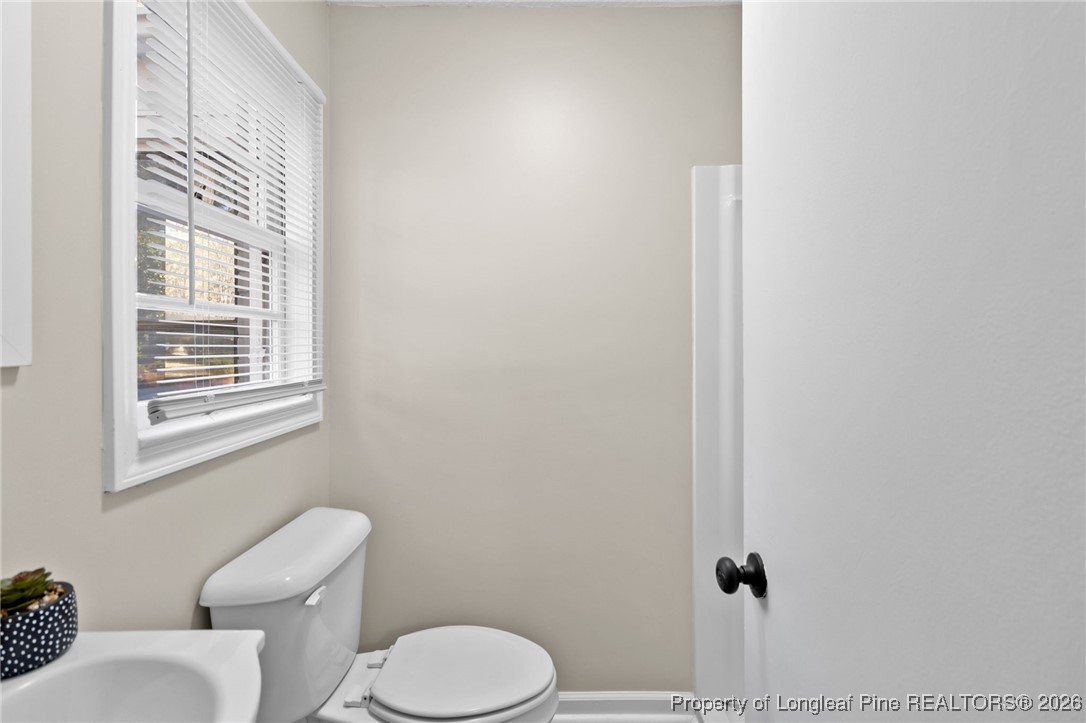 2712 Morganton Road Fayetteville, NC 28303 - Photo 12 of 39 a white toilet sitting next to a bathroom sink