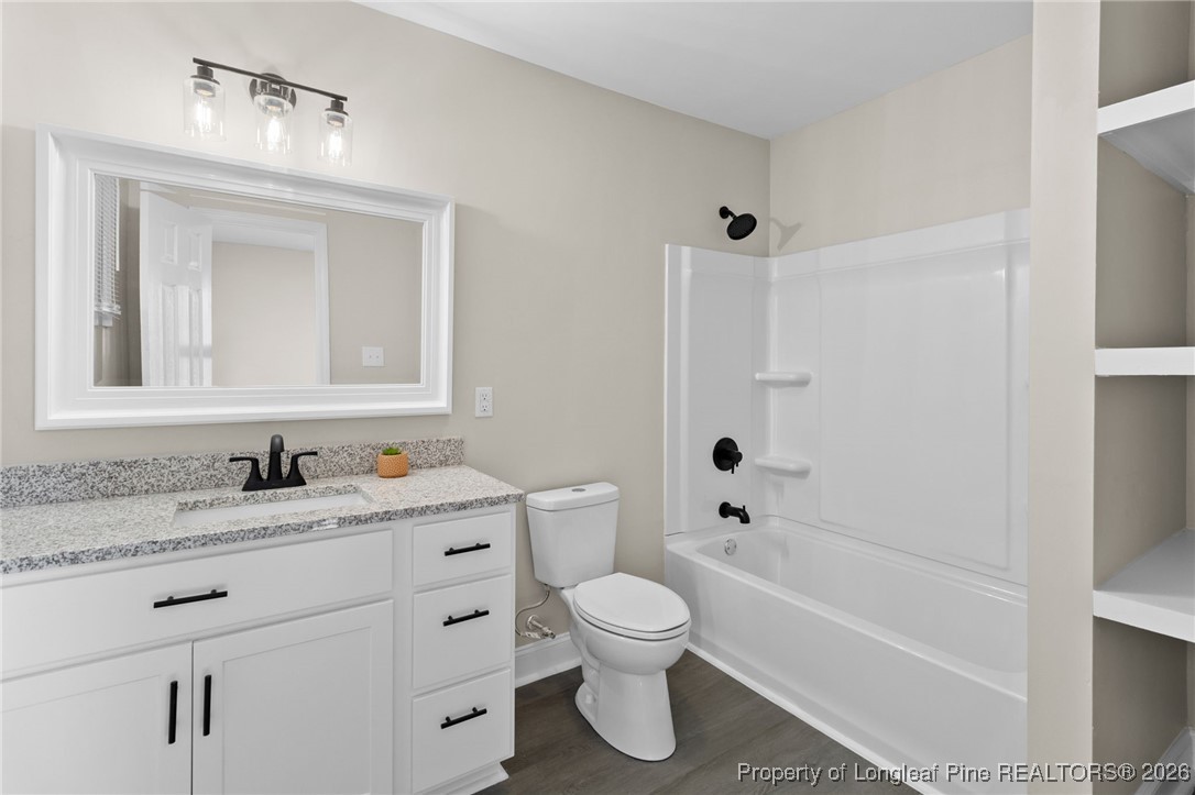 2712 Morganton Road Fayetteville, NC 28303 - Photo 15 of 39 a bathroom with a granite countertop toilet a sink and a bathtub