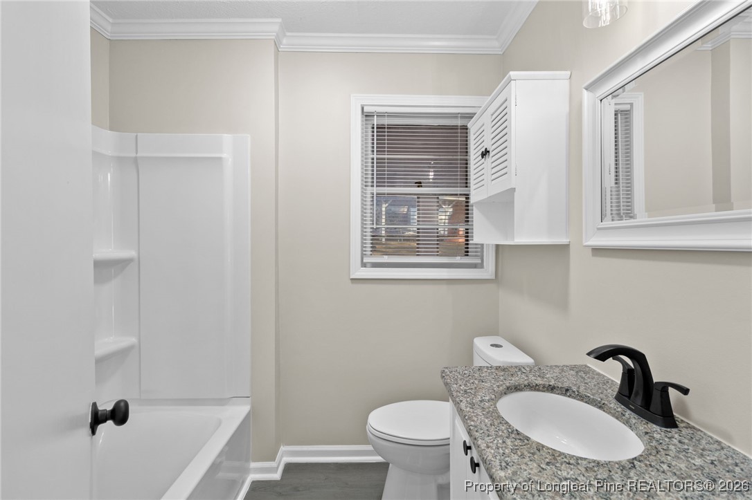 2712 Morganton Road Fayetteville, NC 28303 - Photo 18 of 39 a bathroom with a granite countertop sink toilet a mirror and shower
