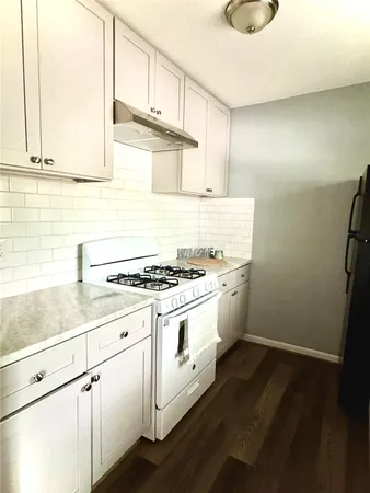 a white stove top oven sitting inside of a kitchen