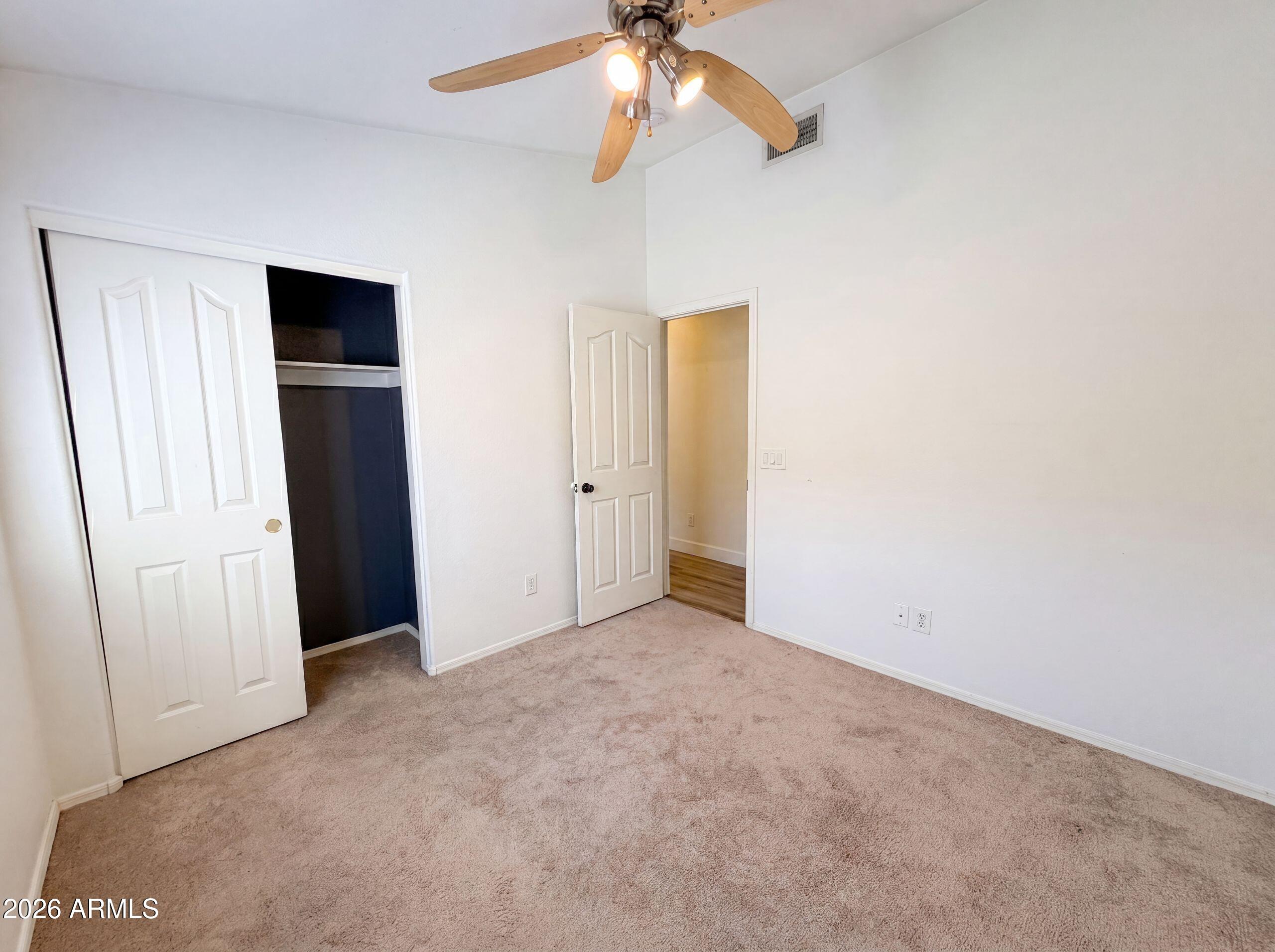 3951 East Timberline Road Gilbert, AZ 85297 - Photo 18 of 28 an empty room with closet and a chandelier fan