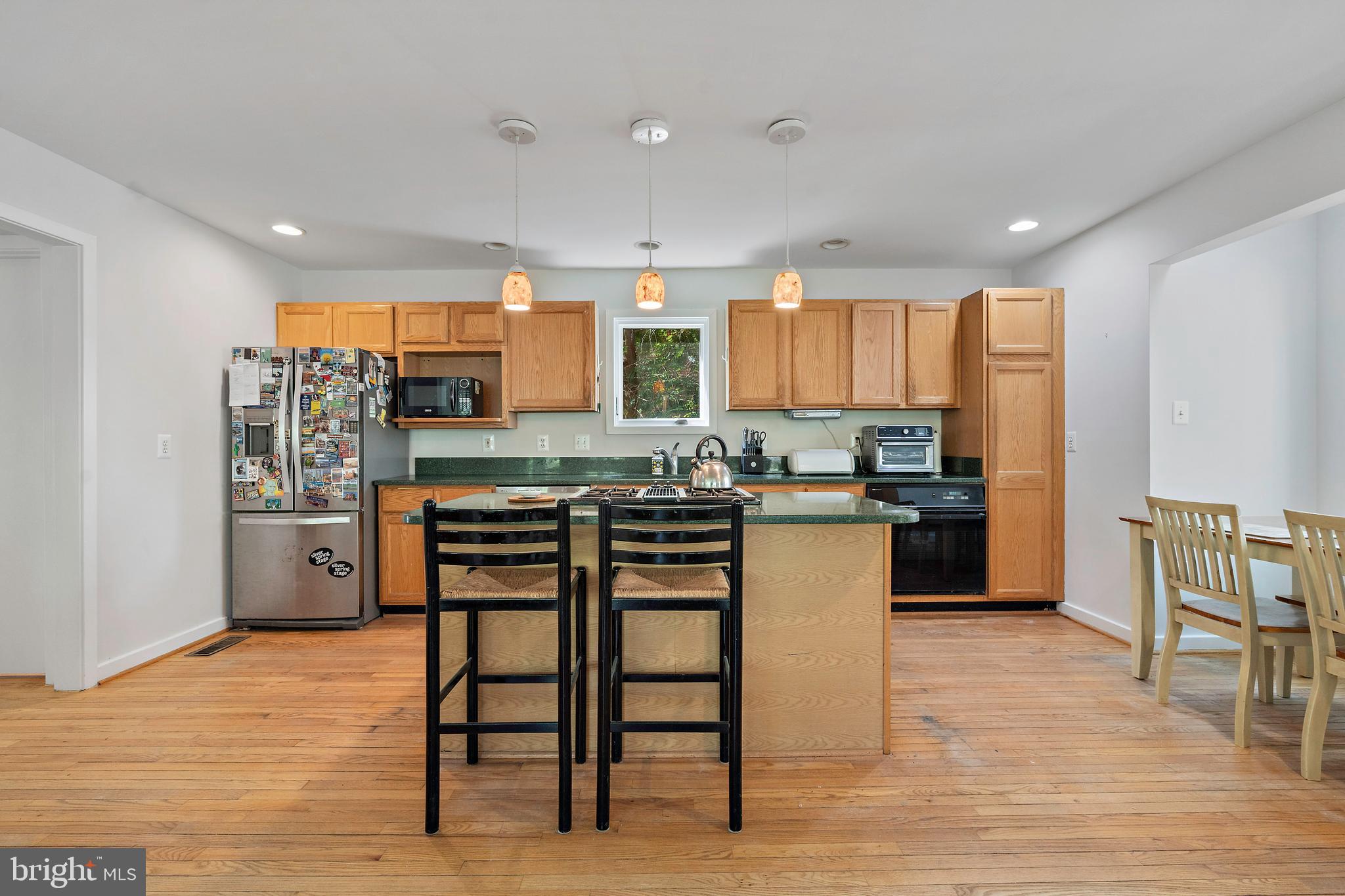 132 Hilltop Road Silver Spring, MD 20910 - Photo 5 of 50 a kitchen with stainless steel appliances kitchen island granite countertop a refrigerator and wooden cabinets