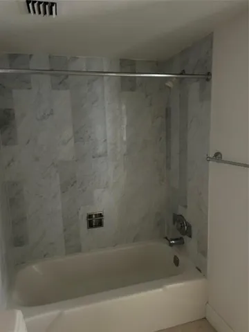 a bathroom with a shower and a bath tub