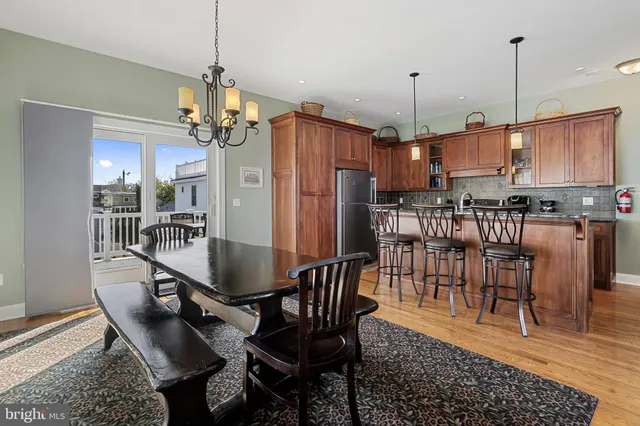 a kitchen with stainless steel appliances granite countertop a stove top oven a sink a dining table and chairs