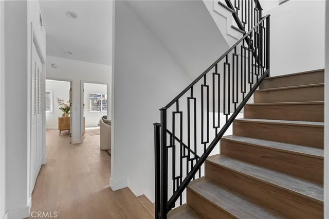 a view of a hallway with wooden floor and staircase