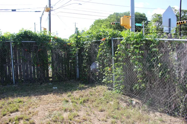 a view of a yard with plants and wooden fence