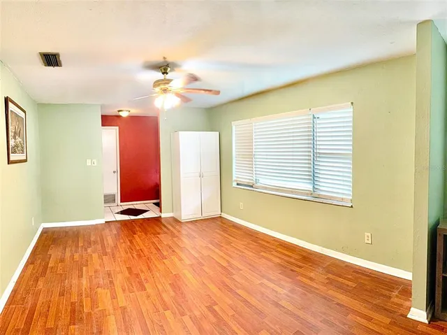 a view of a room with wooden floor and ceiling fan