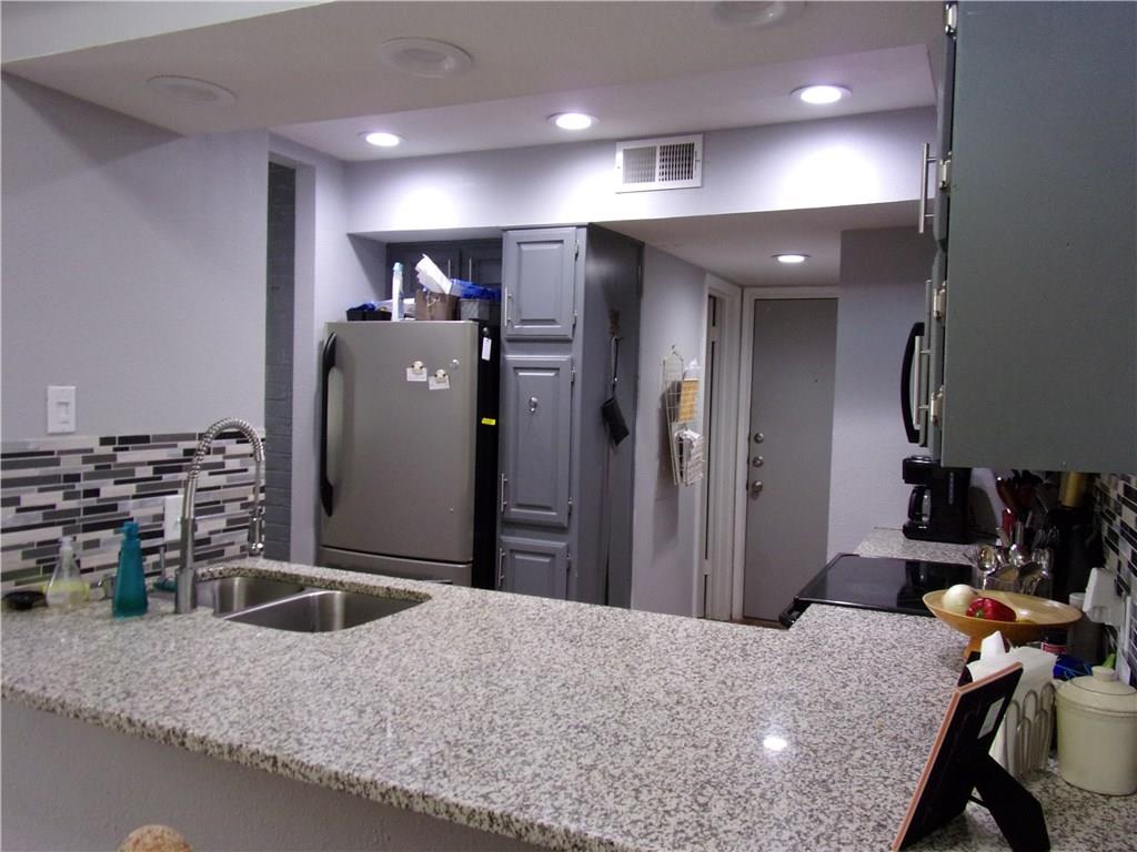 18240 Midway Road, Unit 105 Dallas, TX 75287 - Photo 2 of 37 a kitchen with a refrigerator and a sink