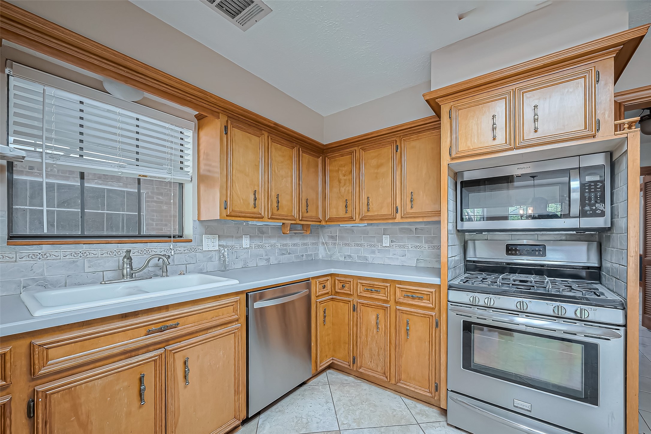 18307 Champion Forest Drive Spring, TX 77379 - Photo 13 of 49 a kitchen with stainless steel appliances granite countertop a sink stove and cabinets
