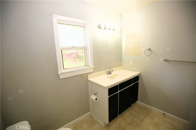 a utility room with a sink vanity and window