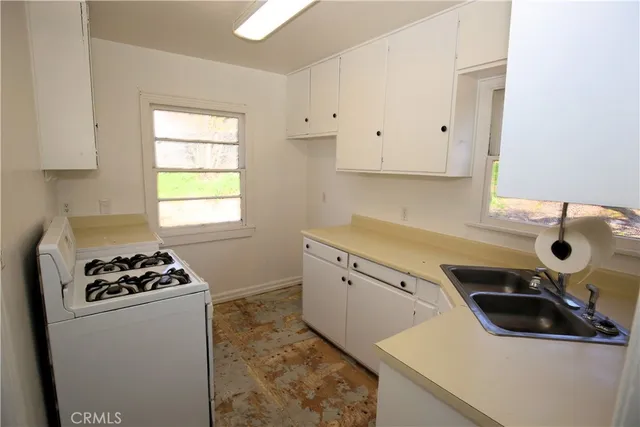 a kitchen with a sink a stove and cabinets