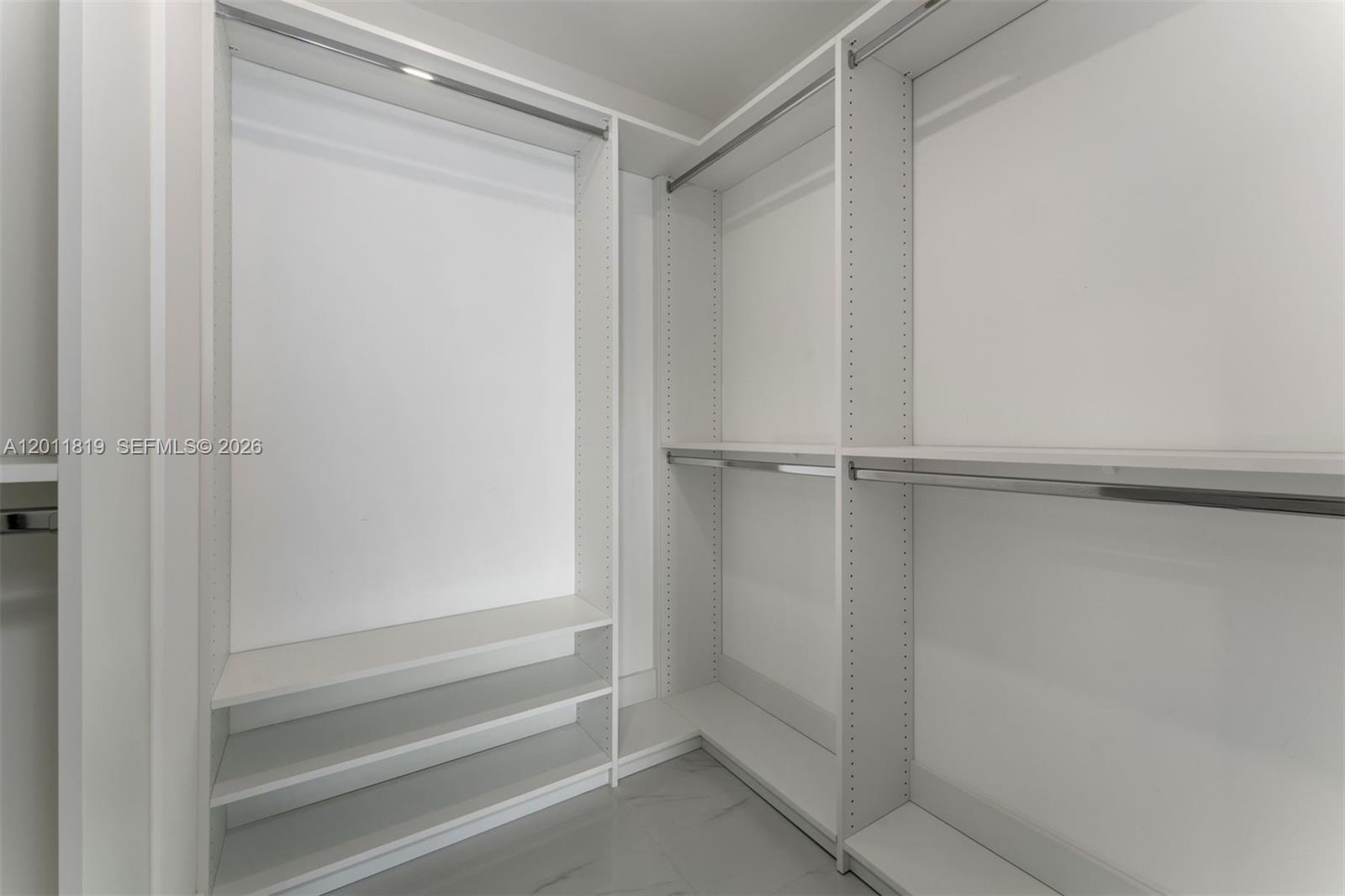 700 Northeast 24th Street, Unit 2504 Miami, FL 33137 - Photo 25 of 52 Serene primary suite offering unobstructed water views, direct terrace access, oversized walk-in closets, and floor-to-ceiling windows for a true 'mansion in the sky' feel.