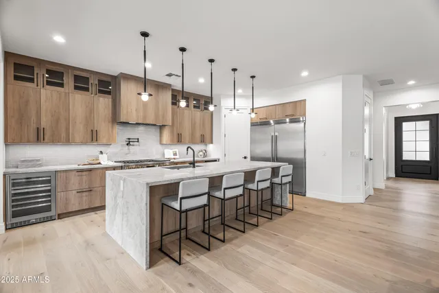 a kitchen with center island white cabinets and stainless steel appliances