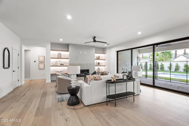 a living room with furniture a large window and a fireplace